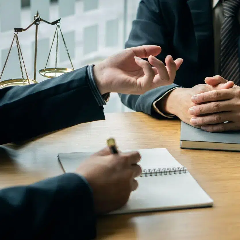 Assault and Battery Attorney seated at a wooden table, engaged in discussion.
