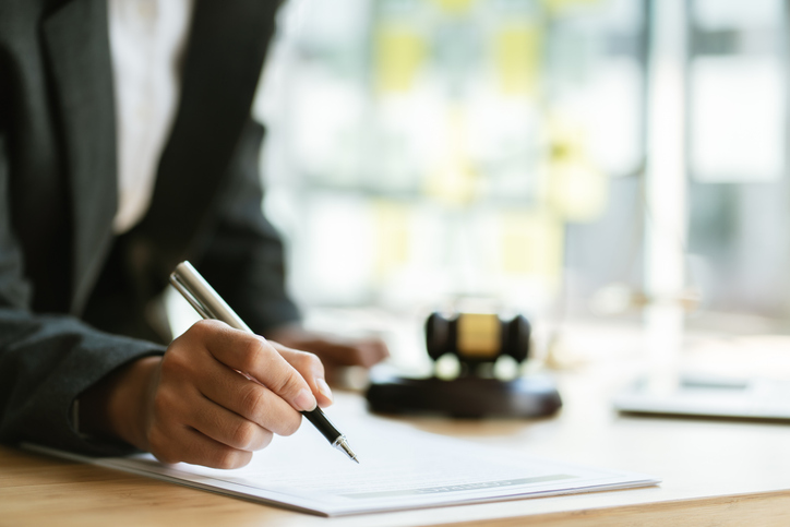 Male lawyer or judge working with contract papers, Law books and wooden gavel on table in courtroom, Justice lawyers at law firm, Law and Legal services concept.