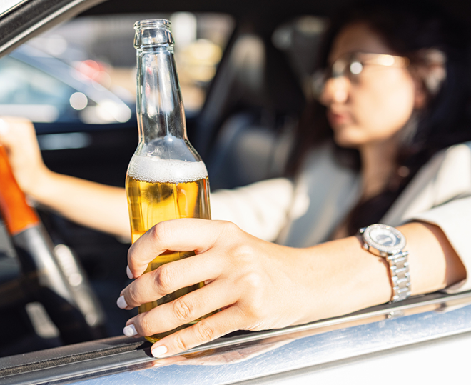 woman driving and drinking beer