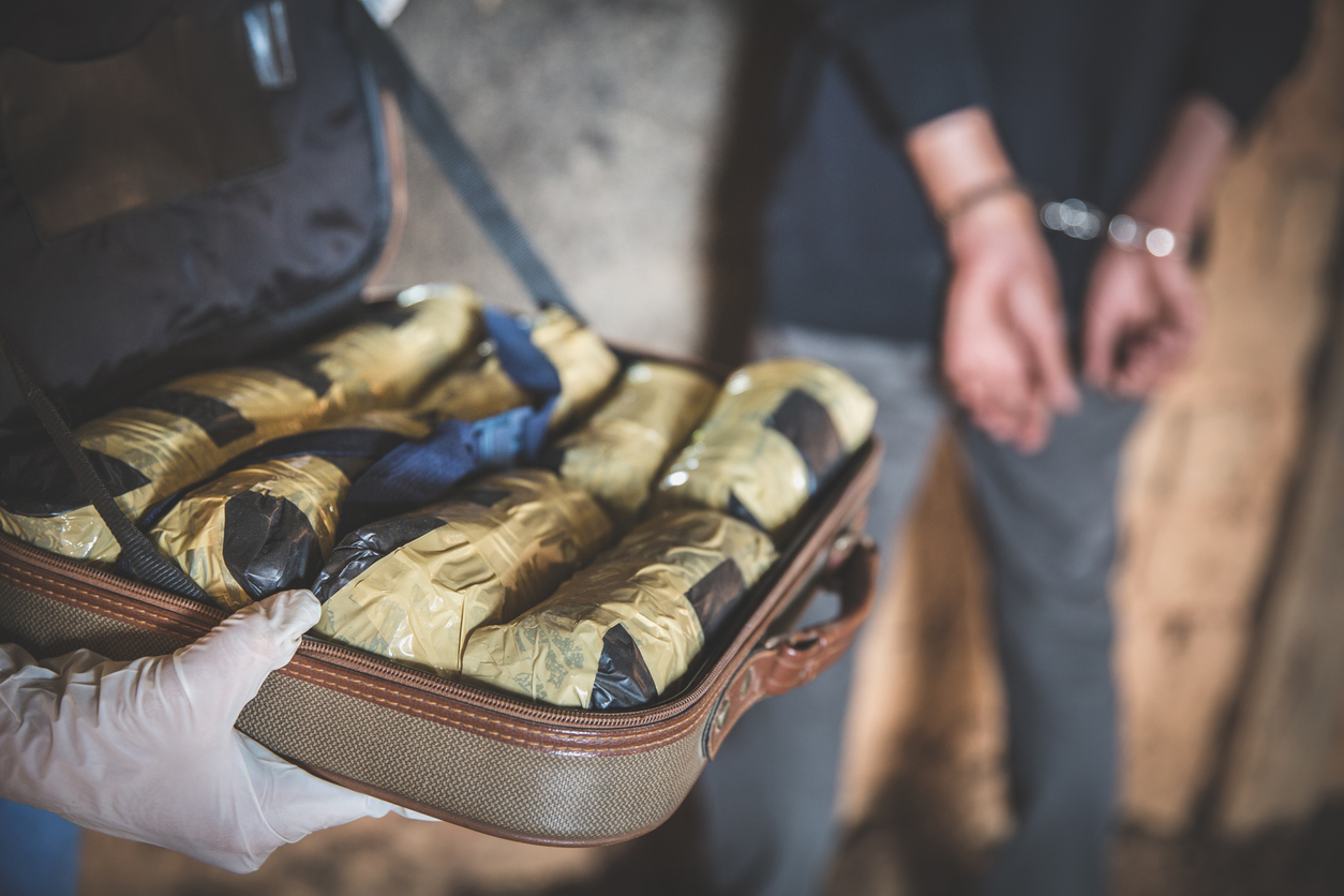Police arrest drug trafficker with handcuffs.