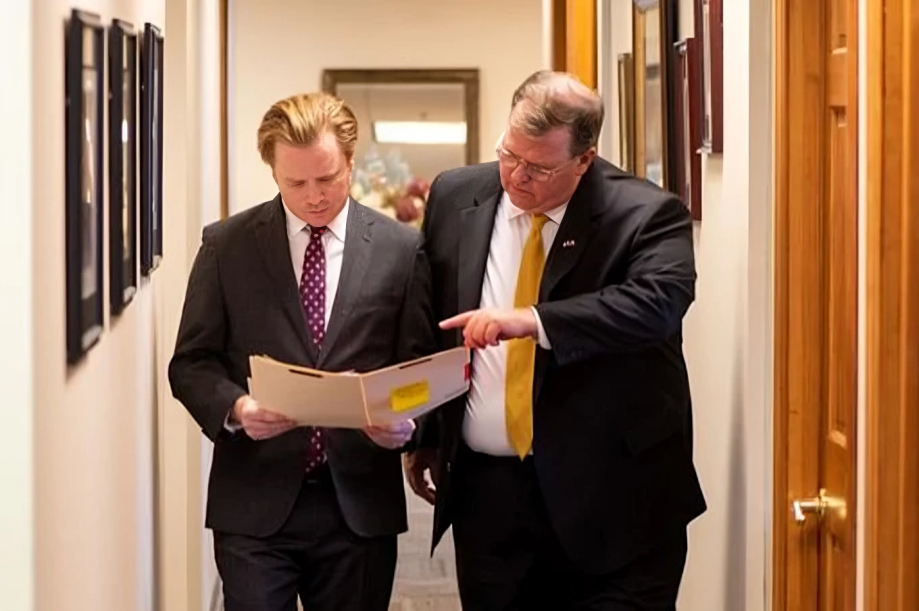 Scott C. Nolan walking with colleague, reviewing legal document in hallway.